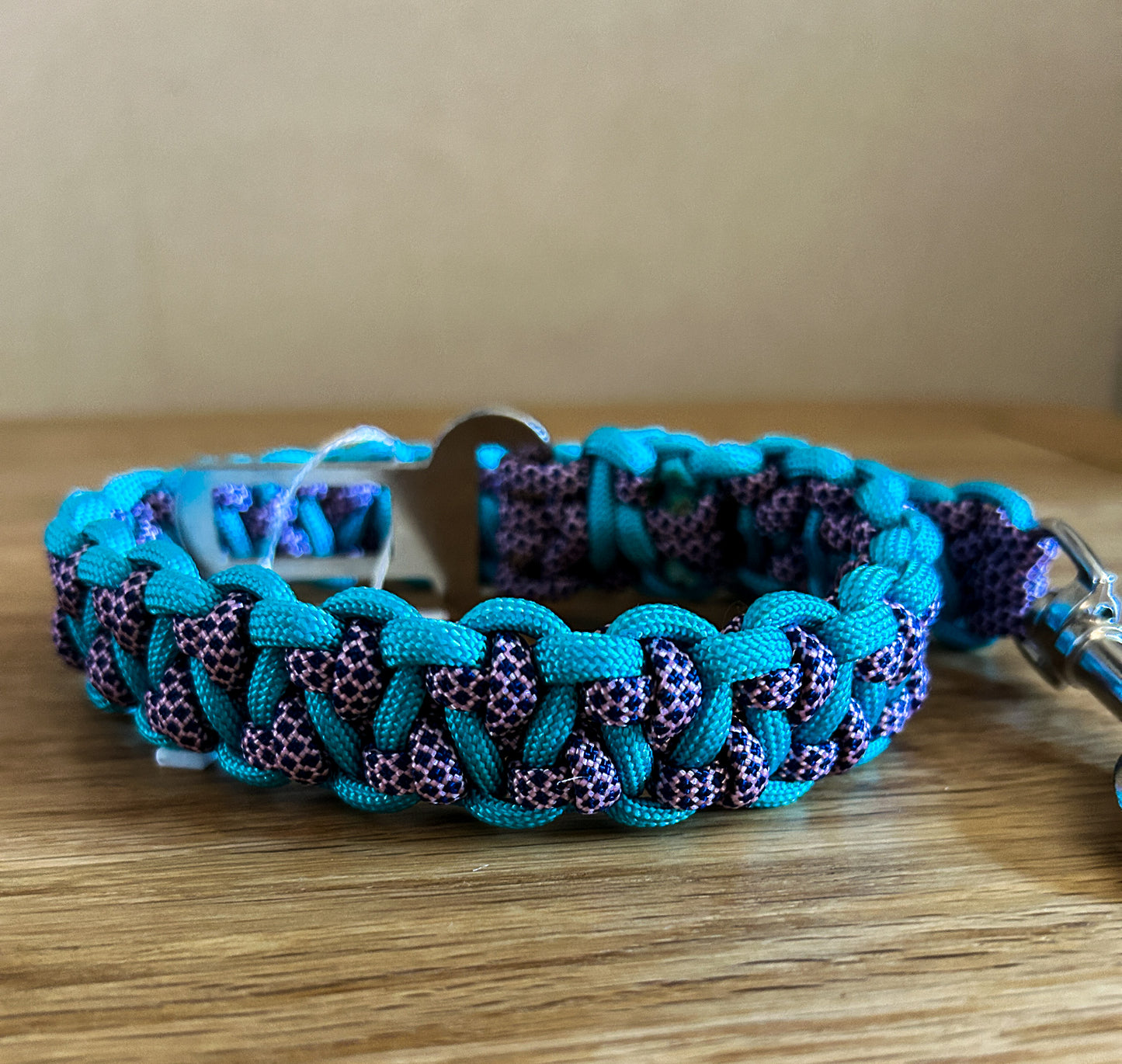 Blue and purple braided dog collar on a wooden surface
