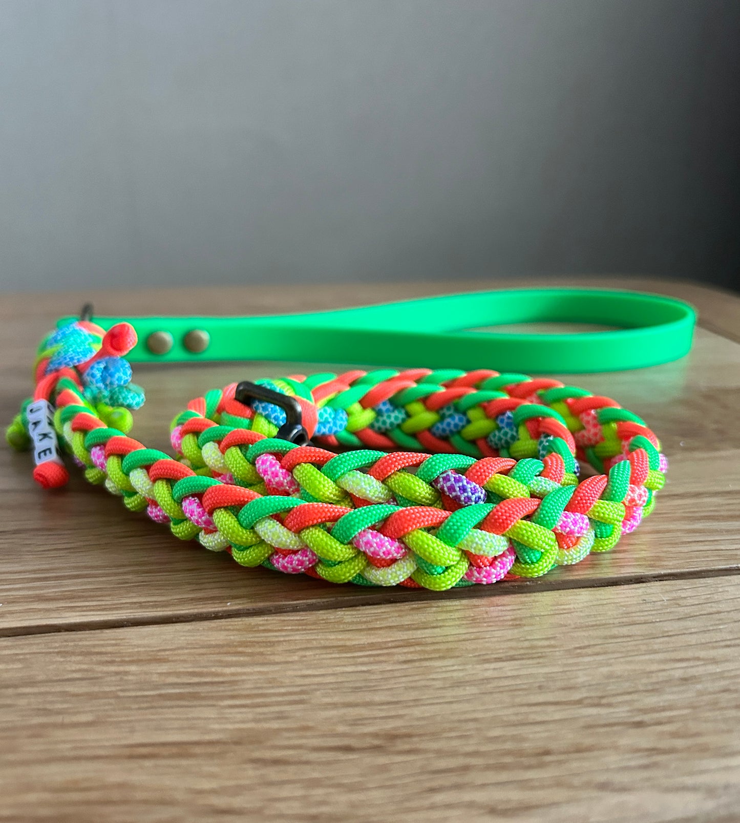 Colorful braided dog leash on a wooden surface with a neutral background