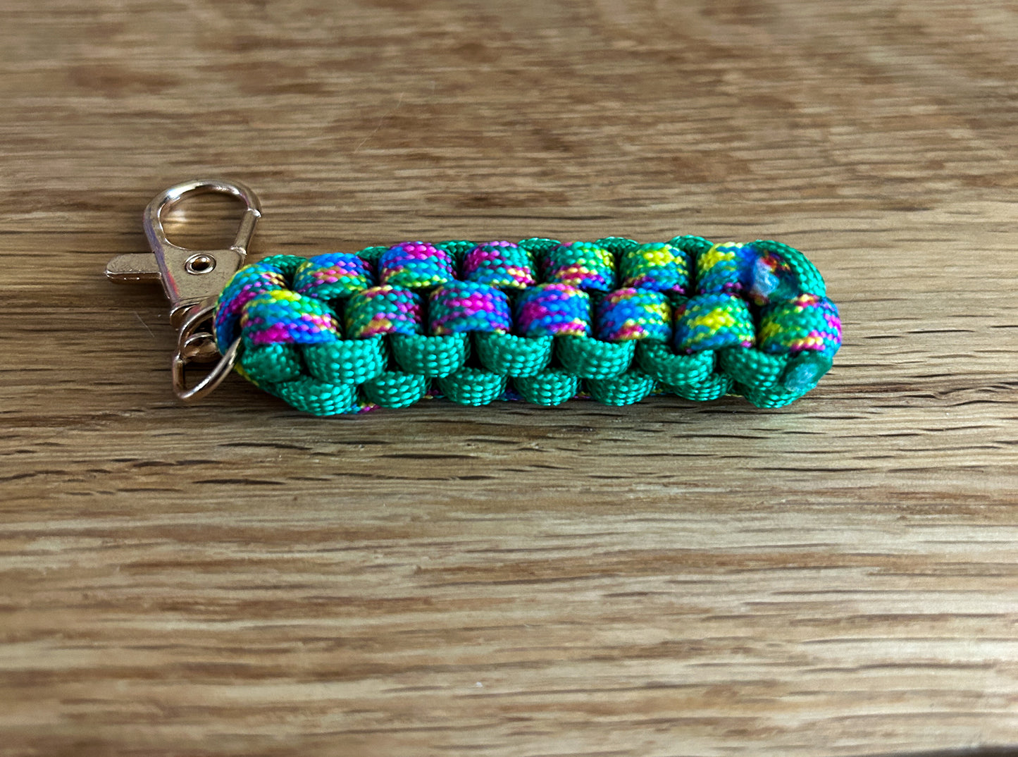 Colorful paracord keychain on a wooden surface