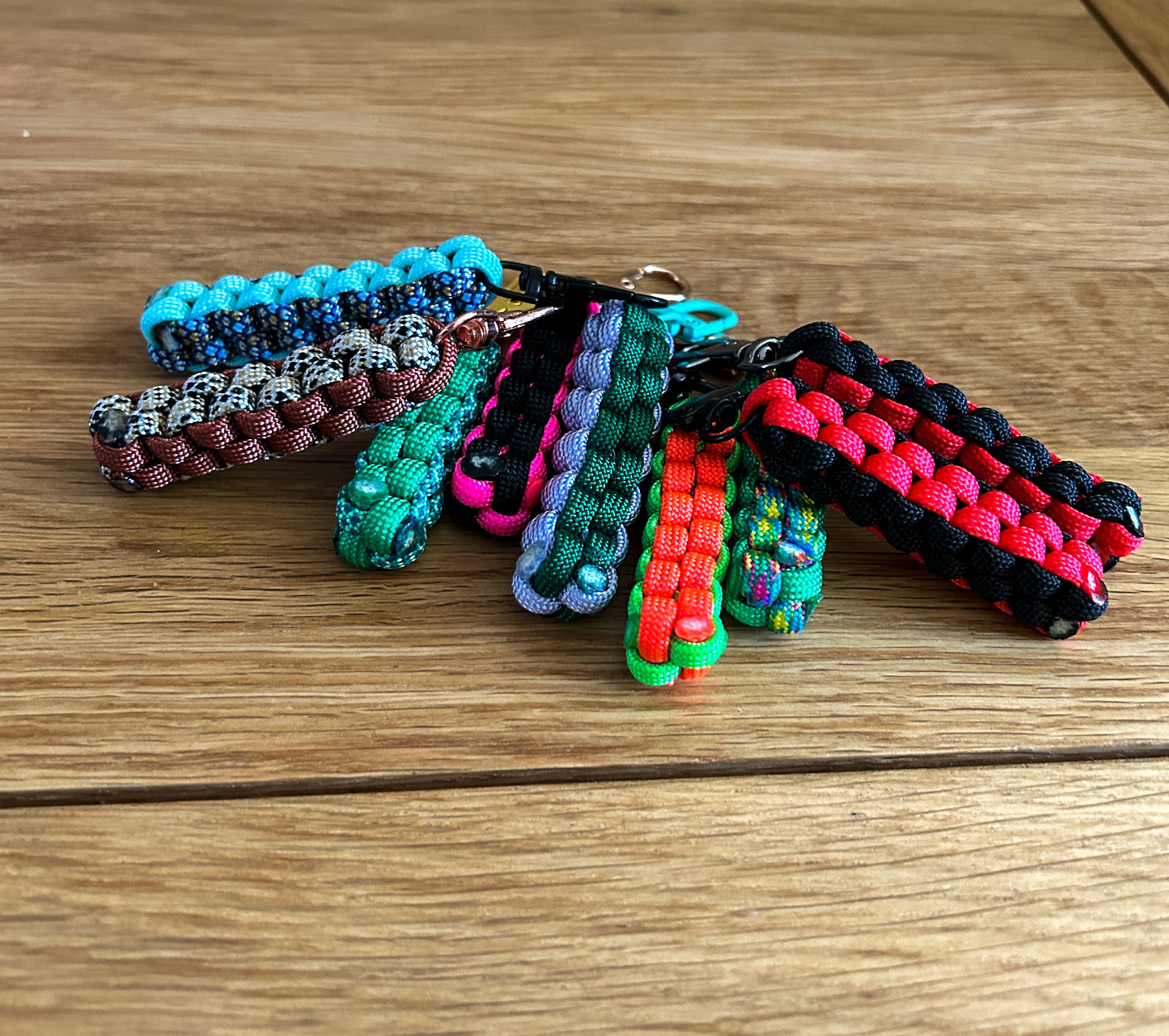 Colorful paracord keychains on a wooden surface
