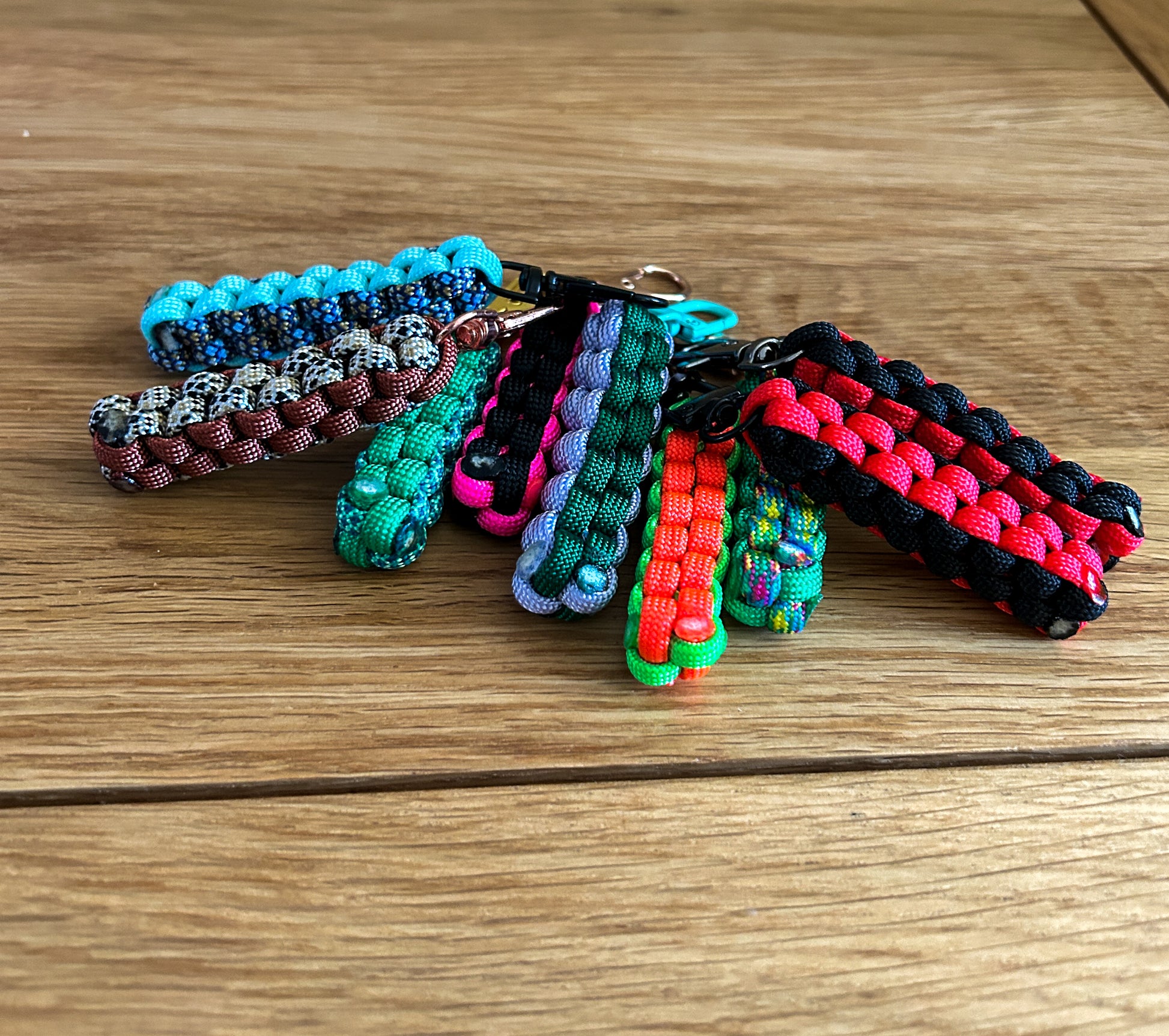 Colorful paracord keychains on a wooden surface
