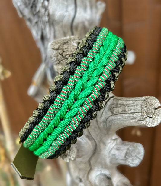Green and black paracord dog collar on a tree stump the background is blurred