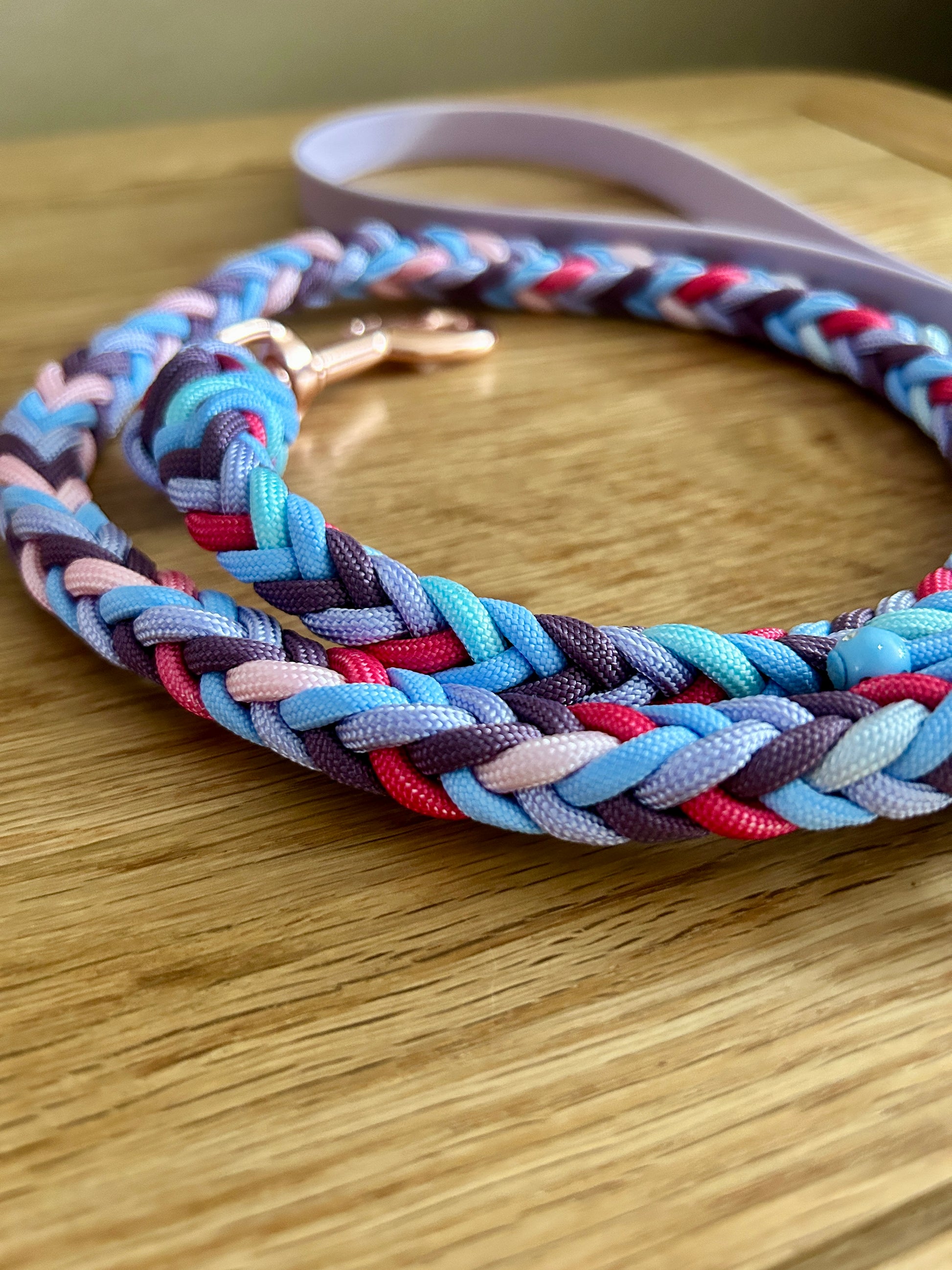 Colorful braided dog leash on a wooden surface