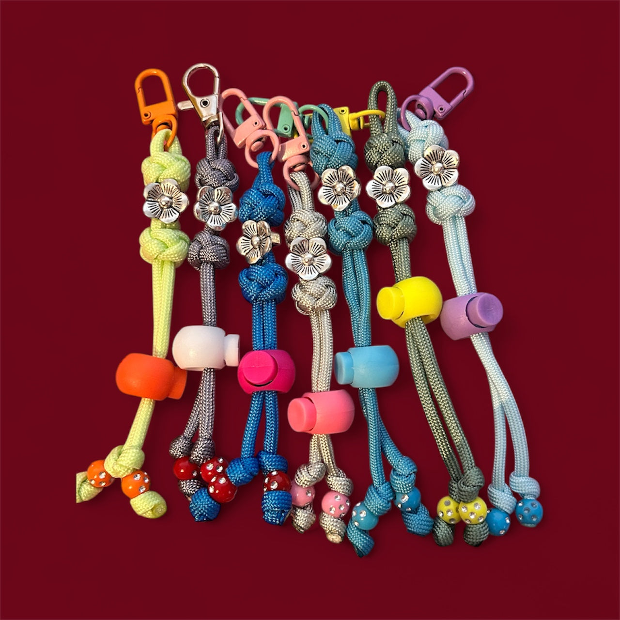 Colorful keychains with various designs on a red background