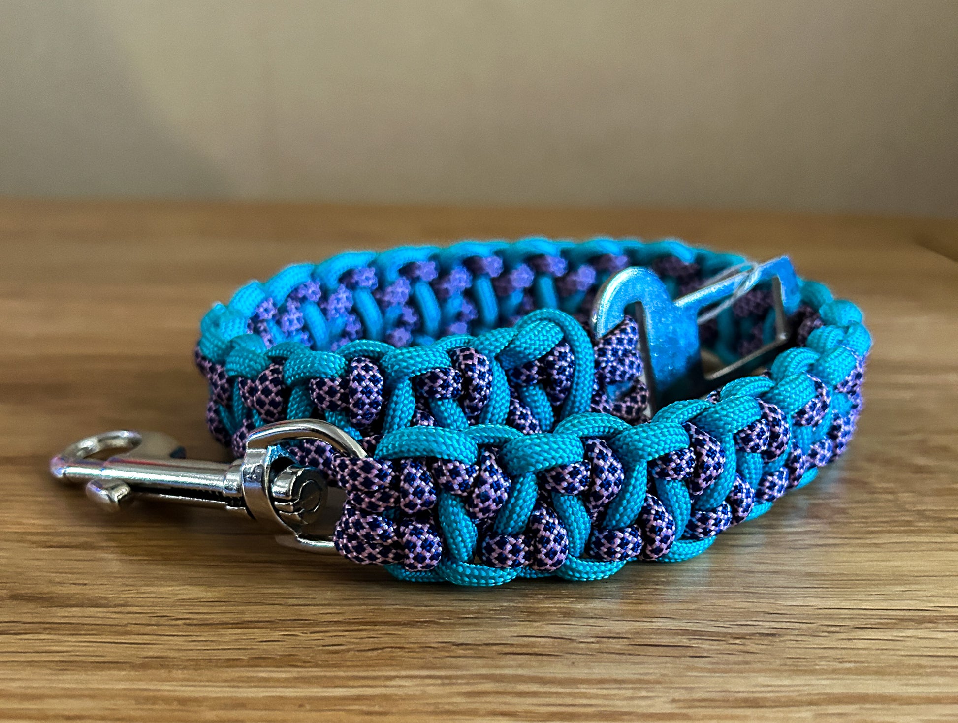 Blue and purple braided dog collar on a wooden surface